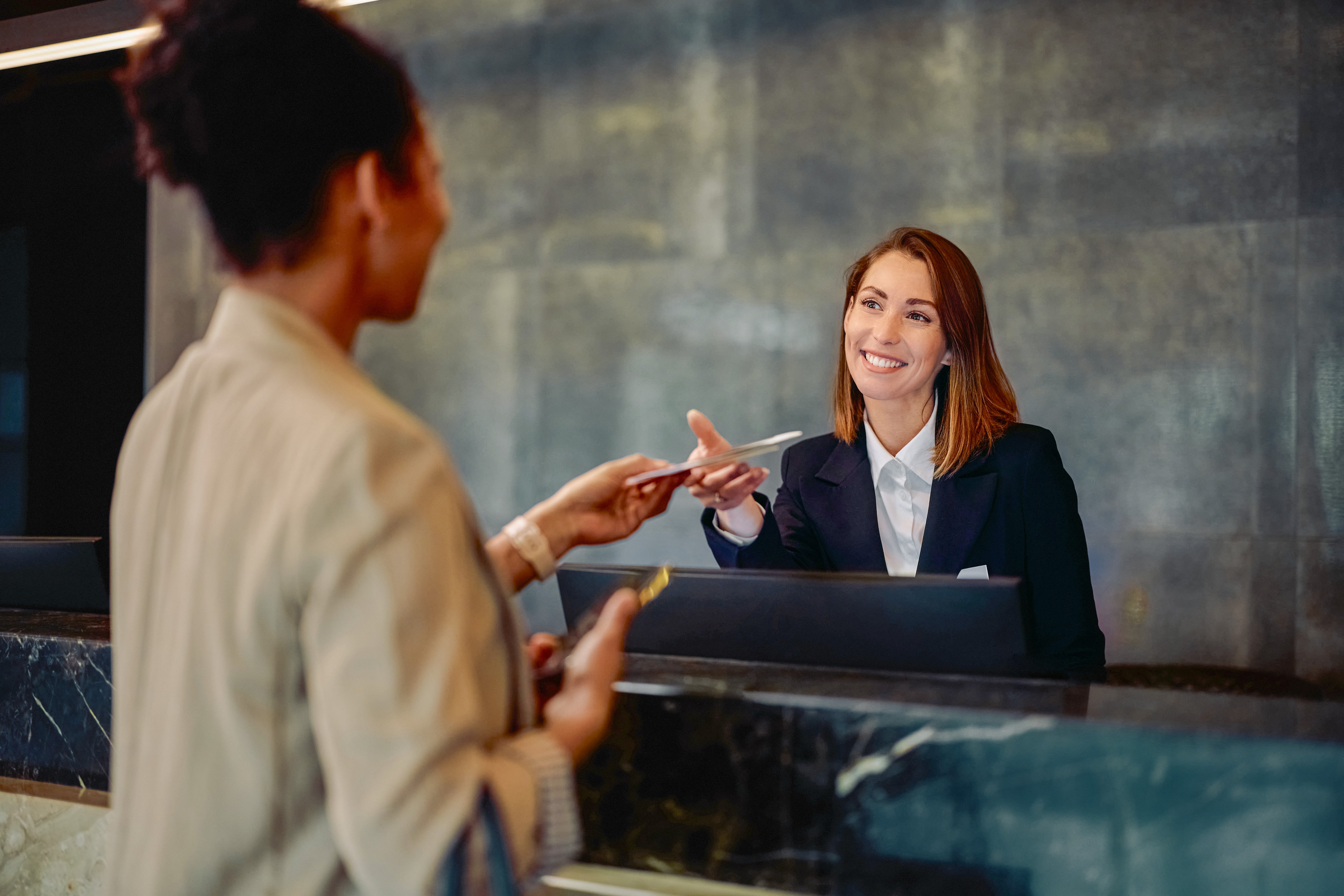 Happy receptionist talking to guest.